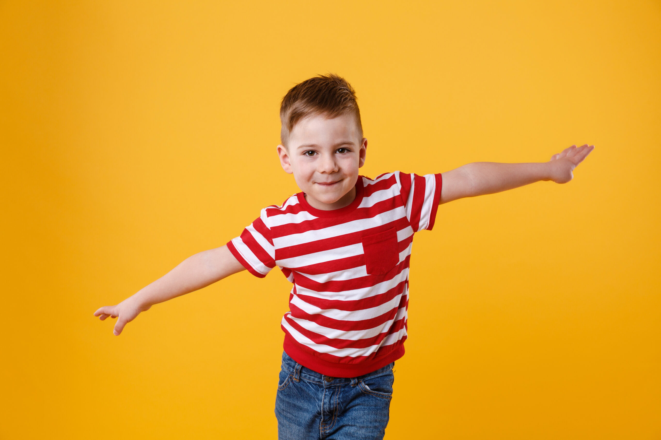 Smiling kid standing with hands spread wide ТОП 50 привітання з днем народження хлопчику своїми словами